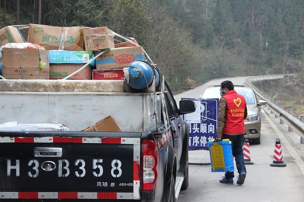 2重慶黔江區(qū)與湖北省咸豐縣大路壩交界疫情檢測全返點，司法局工作人員陳兵為兩省過往物資車輛消毒，兩?。ㄊ校┕ぷ魅藛T共同戰(zhàn)“疫”.jpg